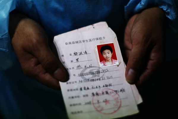 郜传友至今保留着小儿子生前的保险卡，照片上的郜洪涛有着清秀的面容。