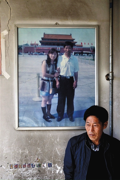 11月14日，承德市平泉县，潘小梅父母的家，潘小梅父亲靠在墙上，身后挂着数年前他和潘小梅在北京的合影照片。