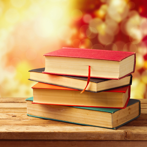 Old vintage books on wooden table over beautiful bokeh autumn background. Back to school concept