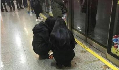 两个女孩蹲着等地铁